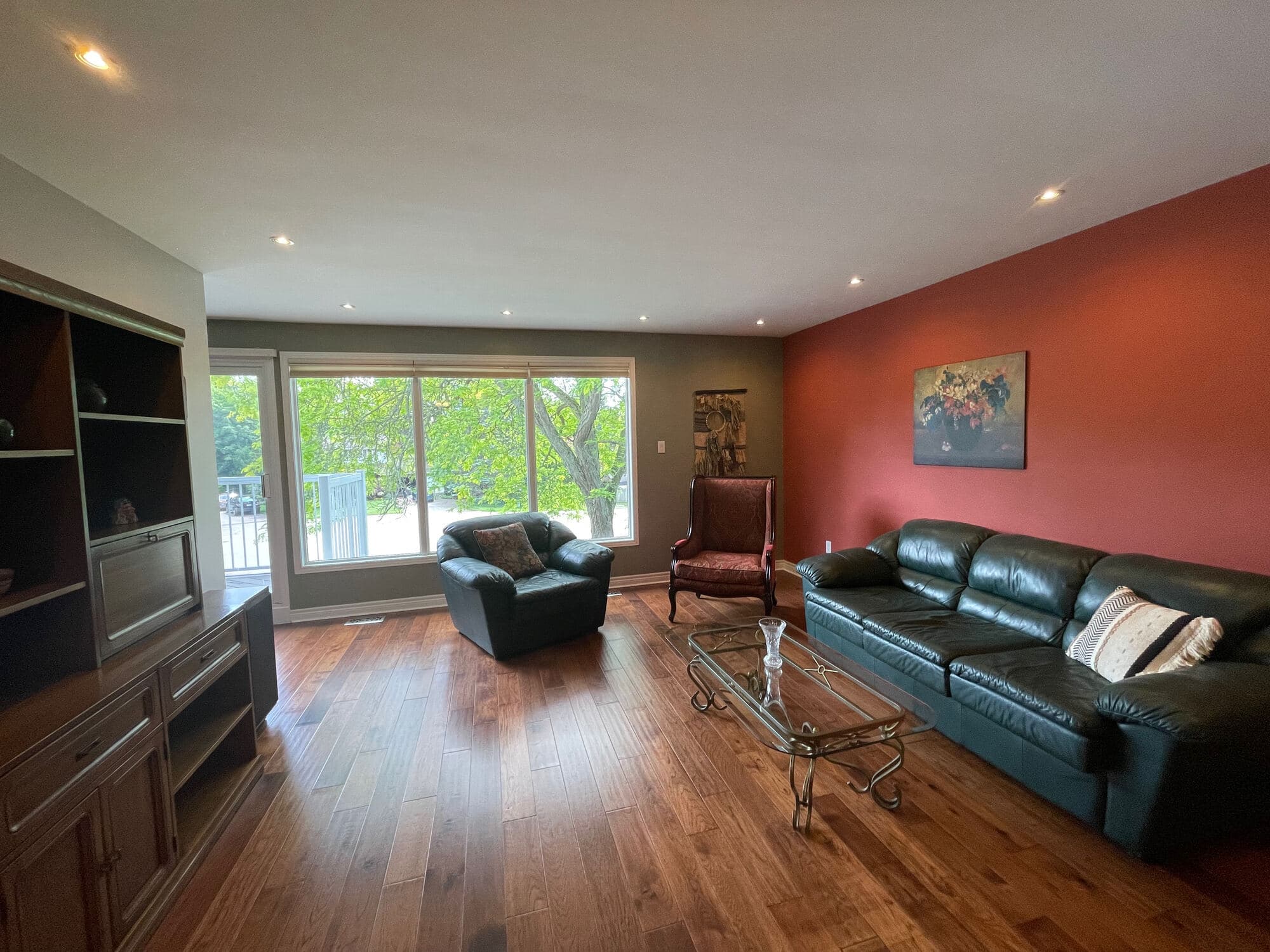 Sunlit living room with hardwood floors and a wide picture window